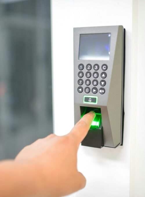 A person uses a fingerprint scanner for secure entry in a business setting.