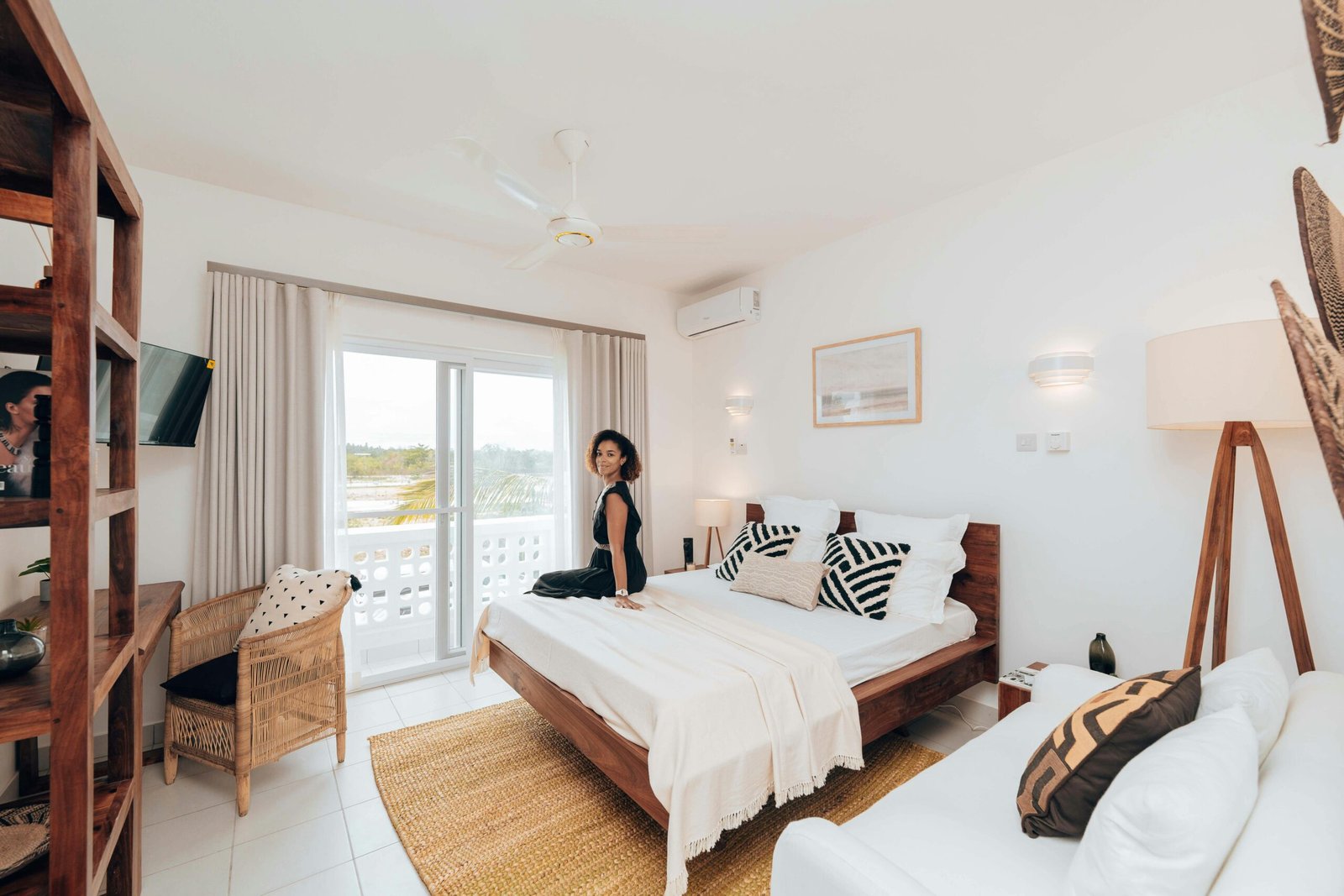 Cozy modern bedroom in Zanzibar featuring contemporary style with a woman seated on the bed.