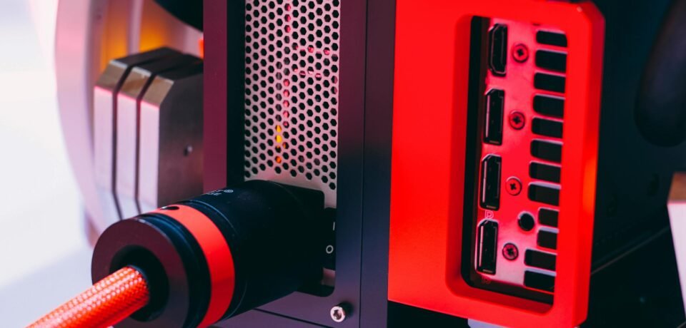 Detailed image of a high-tech computer component with red accents and cable connections.