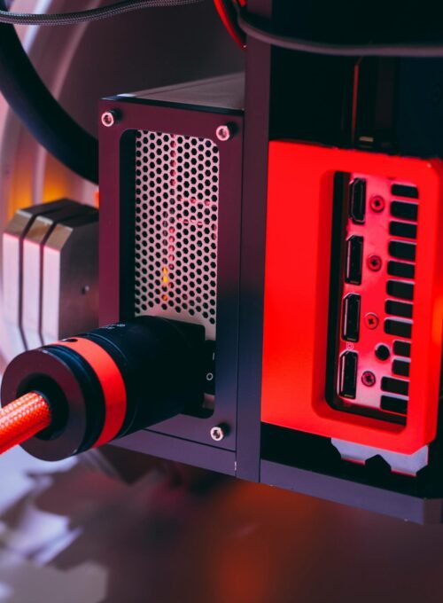 Detailed image of a high-tech computer component with red accents and cable connections.