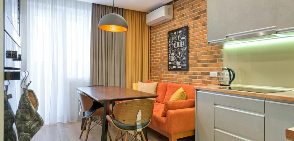 Modern kitchen with brick wall and minimalist furniture in a cozy apartment.