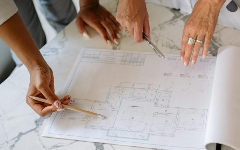 Women collaborating on architectural plans, emphasizing teamwork and precision.